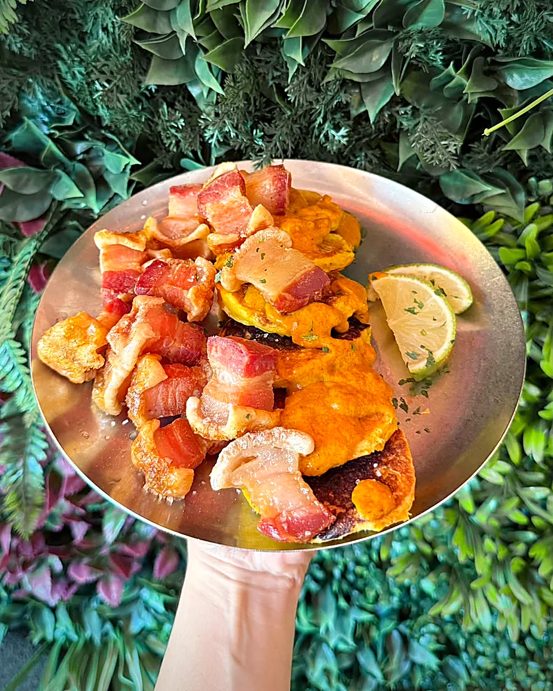 Abrazo de maíz y chicharrón servido en plato de metal